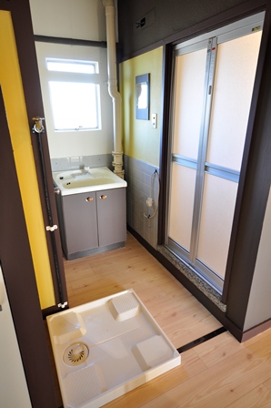 Washroom. There is a washing machine yard behind the wash basin.