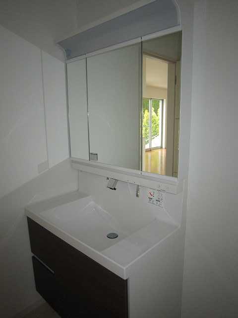 Wash basin, toilet. Vanity of three-sided mirror type is abundant storage capacity