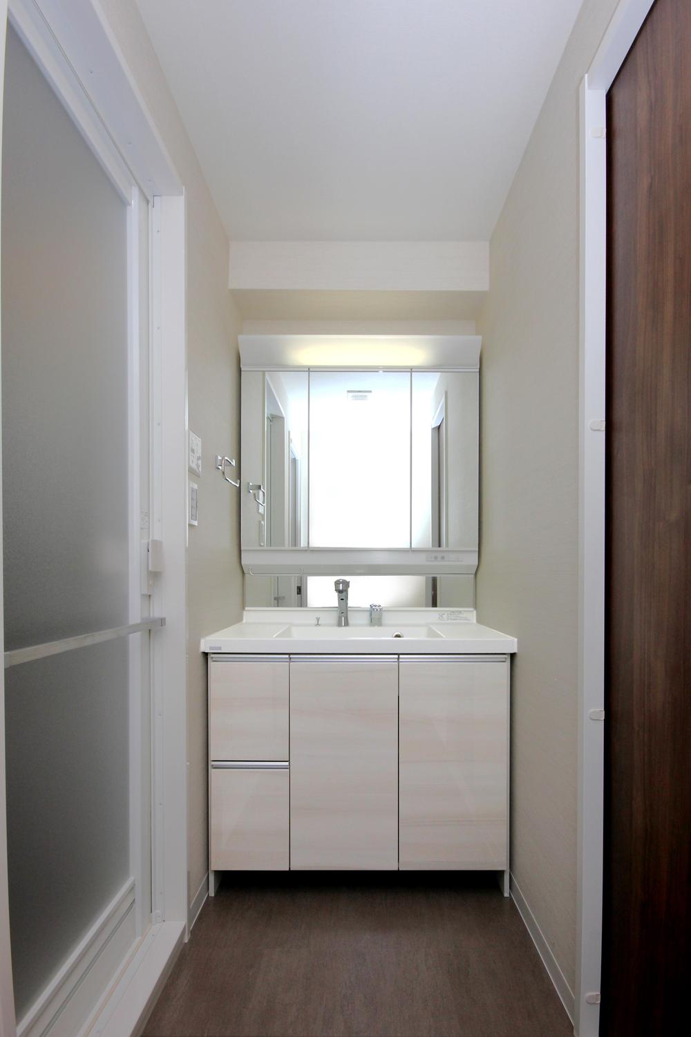 Wash basin, toilet. There is a washing machine storage in the wash room