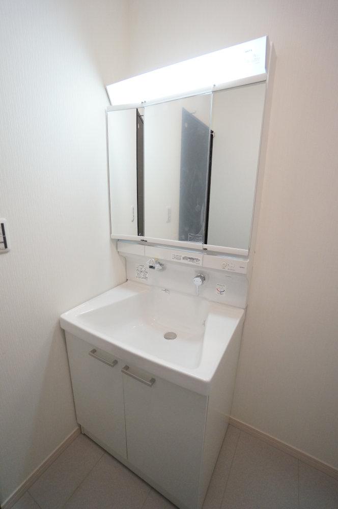 Wash basin, toilet. Three-sided mirror, Shampoo is a vanity with a dresser