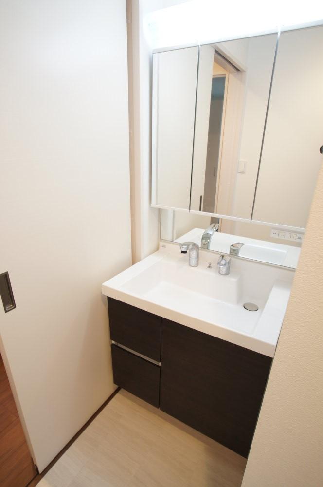 Wash basin, toilet. Shampoo is a dresser with a three-sided mirror with wash basin.
