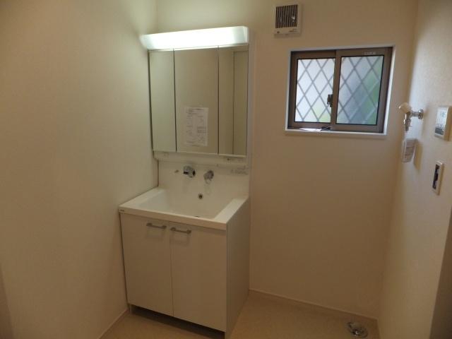 Wash basin, toilet. It is a three-sided mirror type.