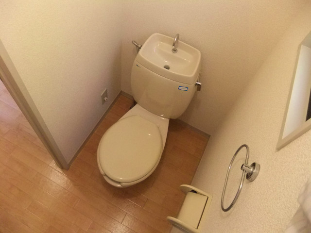 Toilet. There is a shelf on the top there is a window in the toilet