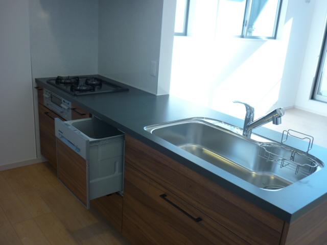 Kitchen. It is an open counter kitchen. It is with a dishwasher.
