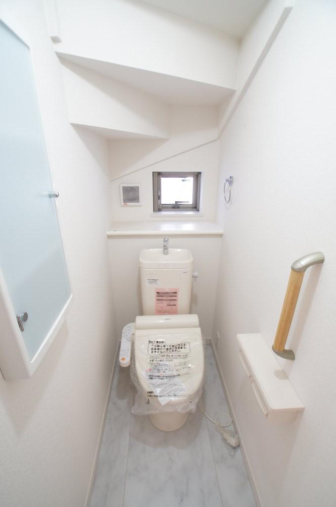 Toilet. Hand wash basin ・ Bidet ・ It marked with a spacious bathroom with storage shelves.