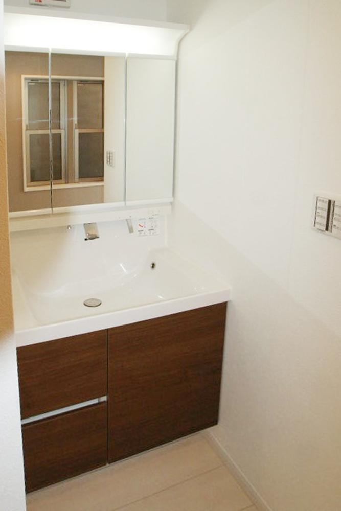 Wash basin, toilet. Shampoo is a dresser with a three-sided mirror.