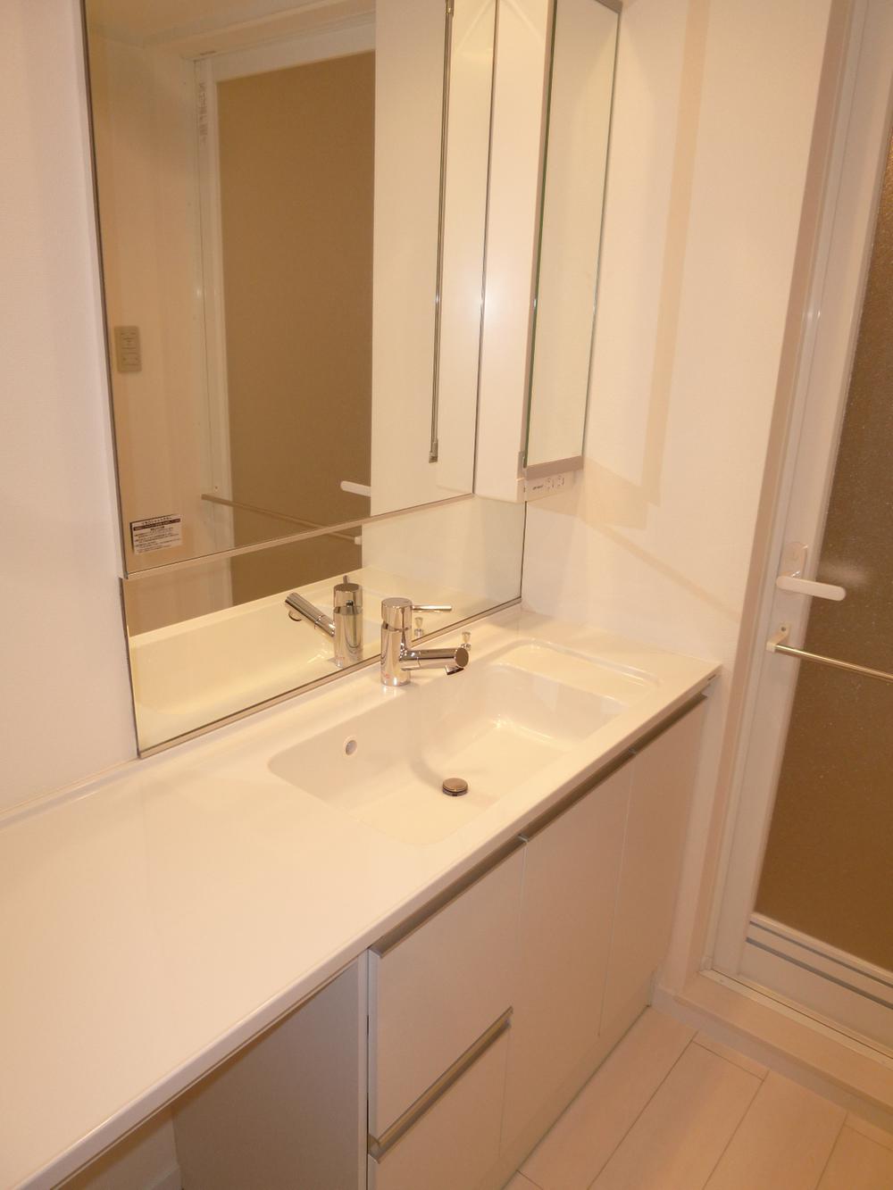 Wash basin, toilet. Wash room with a cleanliness that has been unified with white.